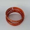 Conjunto de pulseiras indianas de metal com brilhos cor laranja