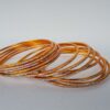 Conjunto de pulseiras indianas de metal com brilhos cor laranja