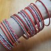Conjunto de 24 pulseiras indianas de metal com brilhos laranja e prateado
