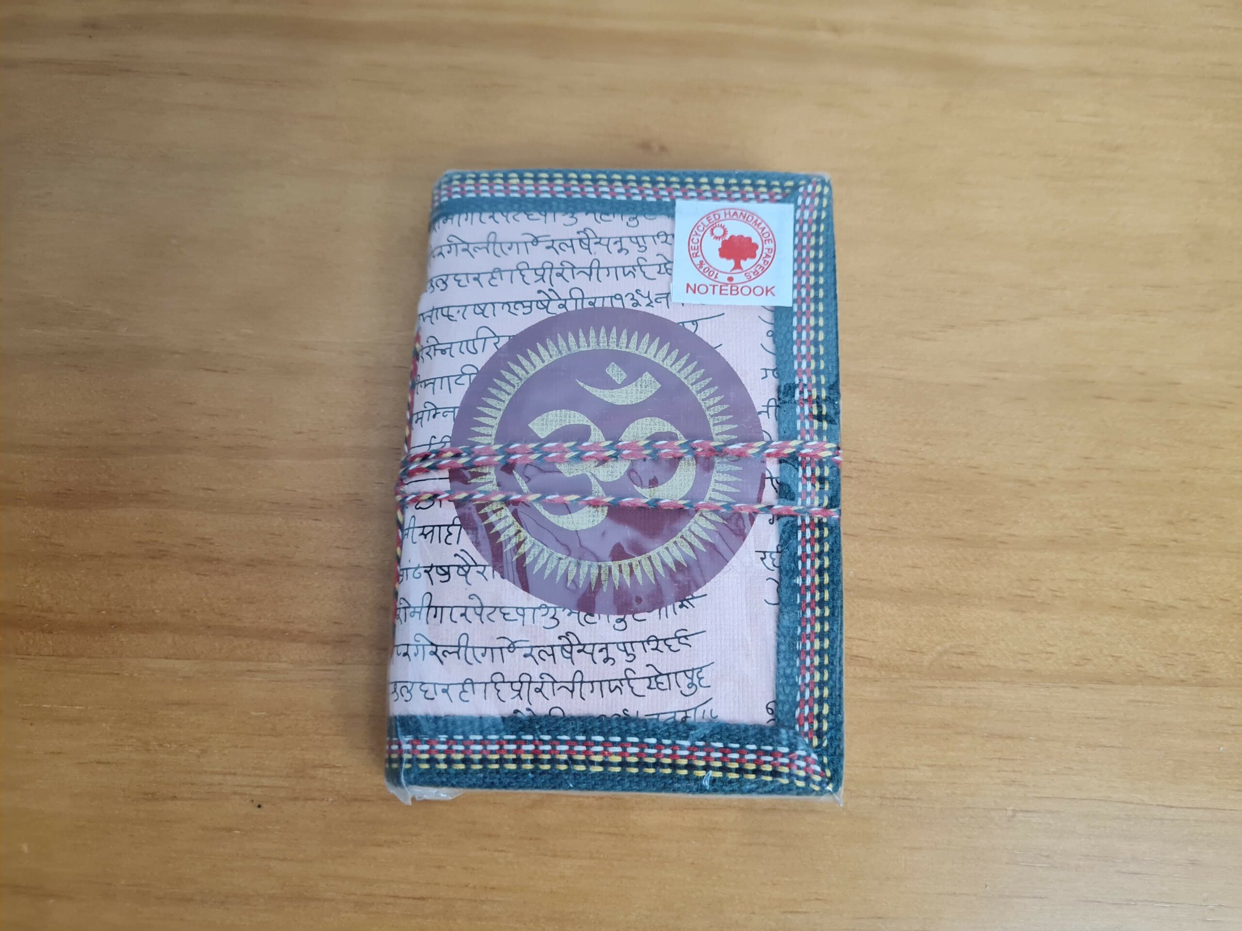 Caderno indiano todo artesanal com papel reciclado e folhas sem pauta. A capa é pintada a mão e costurado com borda artesanal também. 13cmx8cm bege rosado