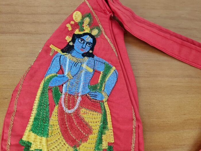 Bolsinha de Japamala estampa bordada de Krishna tocando flauta cor goiaba