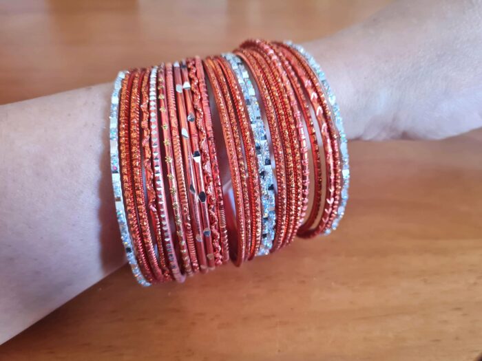 Conjunto de pulseiras indianas com brilhos. Possui 7cm de diâmetro, cor laranja com detalhes prateados