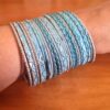 Conjunto de 24 pulseiras indianas de metal com brilhos azul claro e prateado