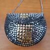 Bolsa indiana de metal prateada com detalhes dourados
