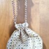 Bolsa indiana de saco creme com florais bordados dourados alça de pérolas